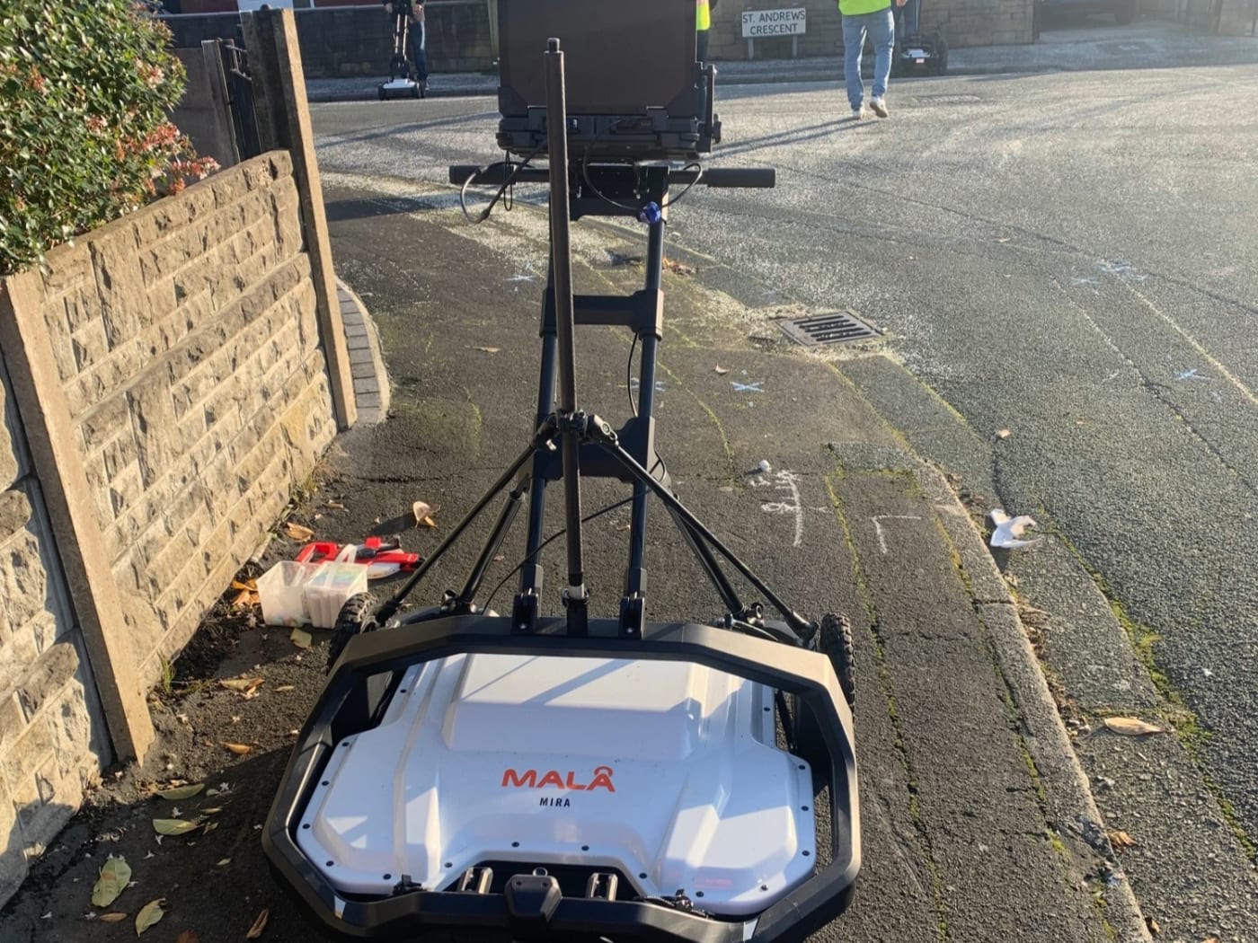 A utility ground-penetrating radar cart with its recording screen, on a UK street